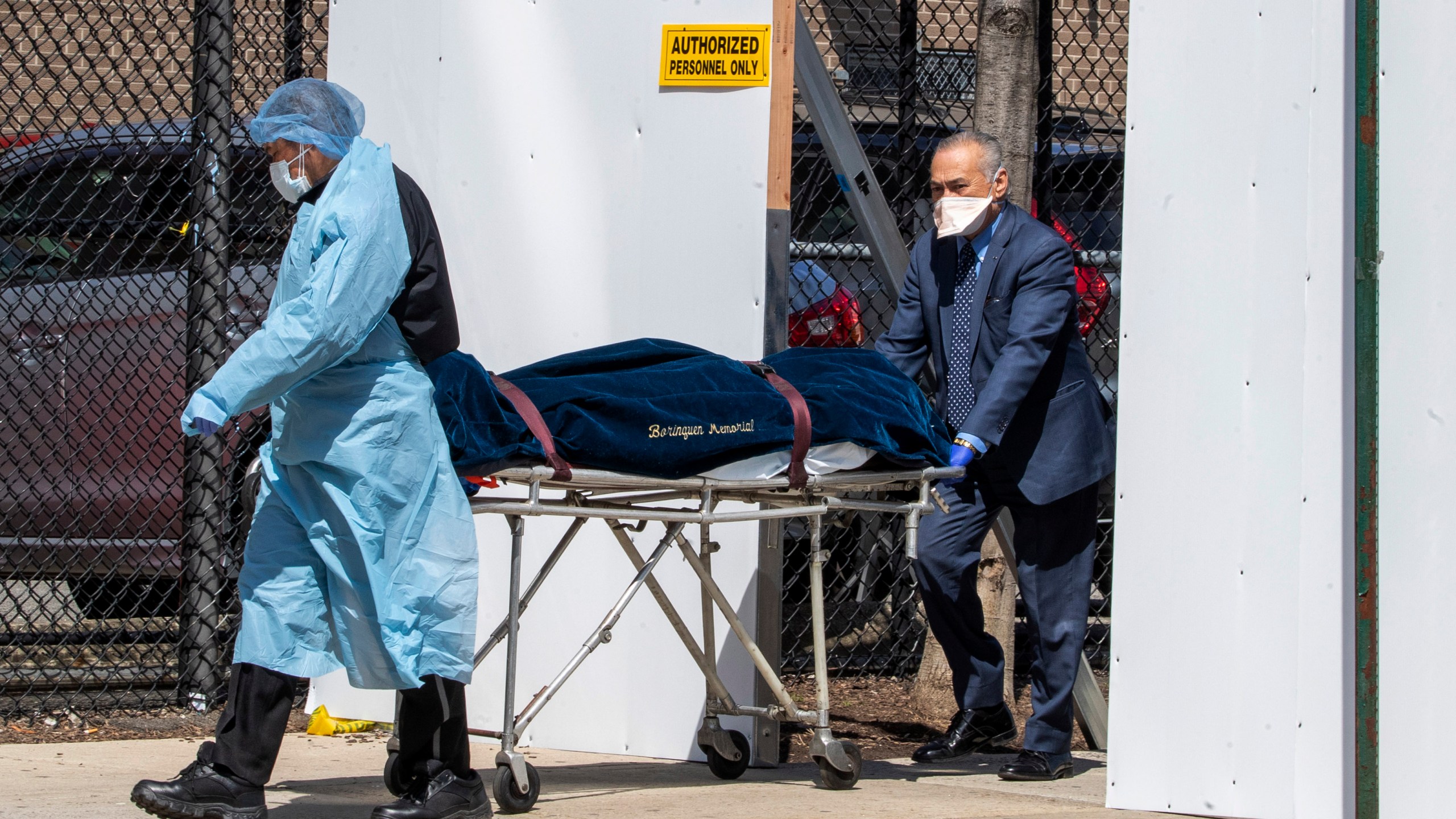 A funeral director and a Wycoff Heights Medical Center, employee transport a body, Wednesday, April 1, 2020, in New York. (AP Photo/Mary Altaffer)