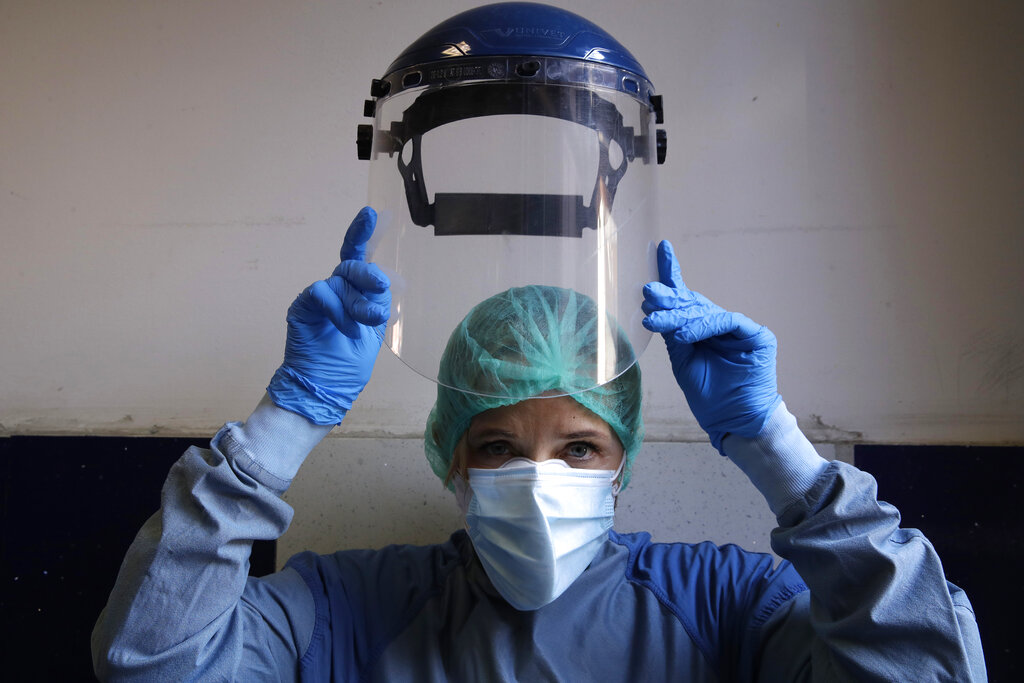 Monica Carfora, deputy head of the emergency of the Santo Spirito Hospital in central Rome, poses to show how to wear protective gear. (AP Photo/Alessandra Tarantino)