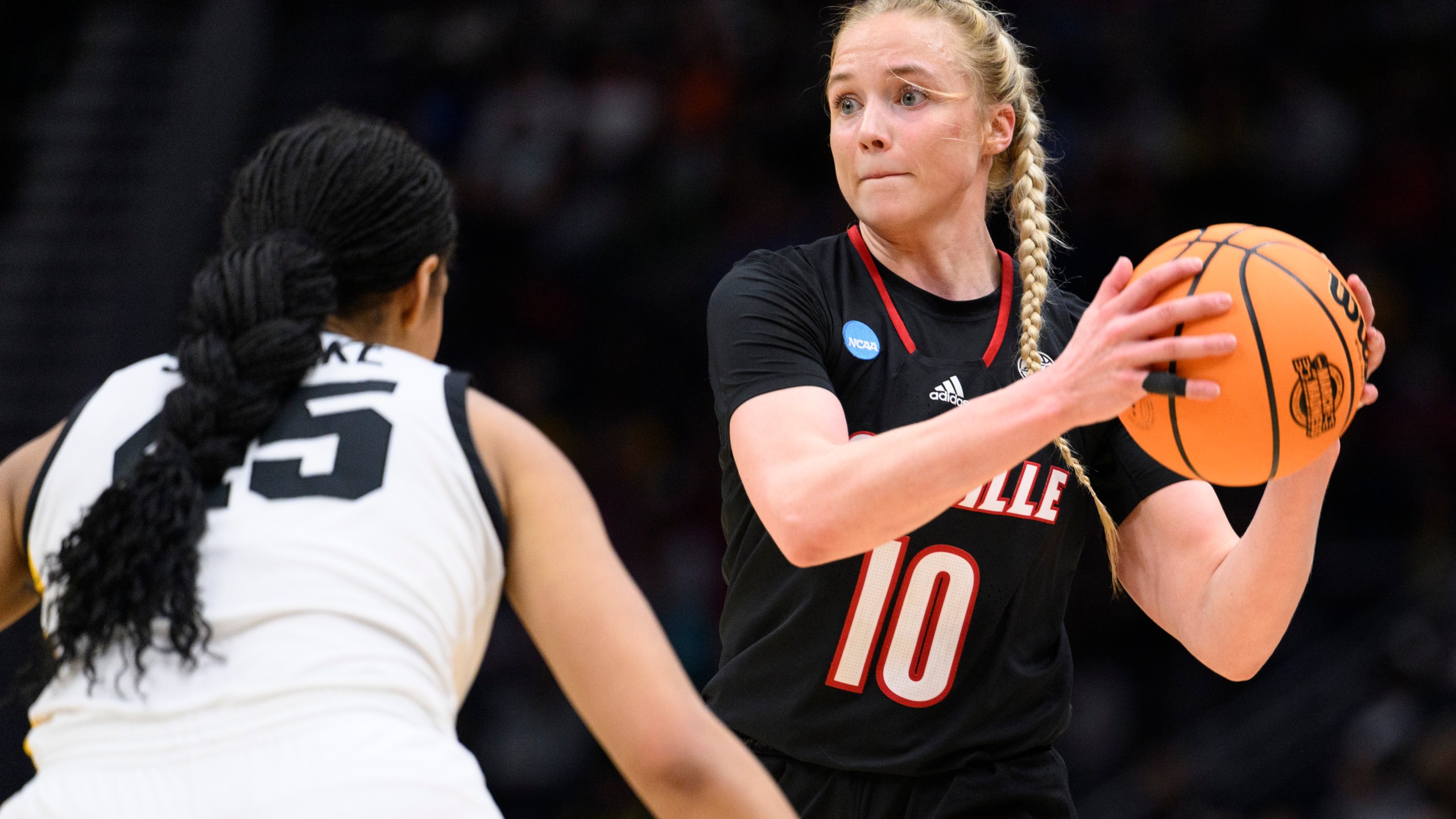 Louisville guard Hailey Van Lith (10) looks for a pass as Iowa forward Hannah Stuelke defends in the second half of an Elite 8 college basketball game of the NCAA Tournament, Sunday, March 26, 2023, in Seattle. (AP Photo/Caean Couto)