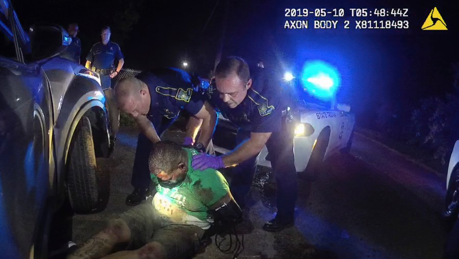 FILE - This image from the body camera of Louisiana State Police Trooper Dakota DeMoss shows his colleagues, Kory York, center left, and Chris Hollingsworth, center right, holding up Ronald Greene before paramedics arrived on May 10, 2019, outside of Monroe, La. (Louisiana State Police via AP, File)