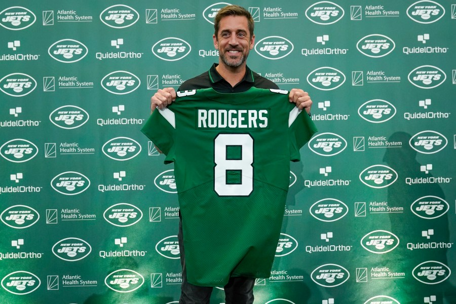 New York Jets' quarterback Aaron Rodgers poses with a jersey after a news conference at the NFL football team's training facility in Florham Park, N.J., Wednesday, April 26, 2023. (AP Photo/Seth Wenig)