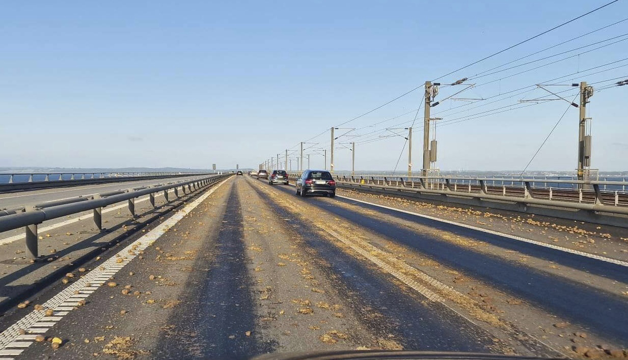 Potatoes are seen scattered across the carriageway on the western part of the Great Belt Bridge, Denmark, Thursday, June 1, 2023. A 57-year-old truck driver was Thursday detained after loads of potatoes have found on the key bridge linking two Danish islands, police said, adding the man was suspected of recklessly causes imminent danger to others. A first spill was reported in the westward direction on the Storebaelt bridge at 6.35 a.m., police spokesman Kenneth Taanquist said, adding a similar incident happened shortly after in the opposite direction. (presse-fotos.dk/Ritzau Scanpix via AP)