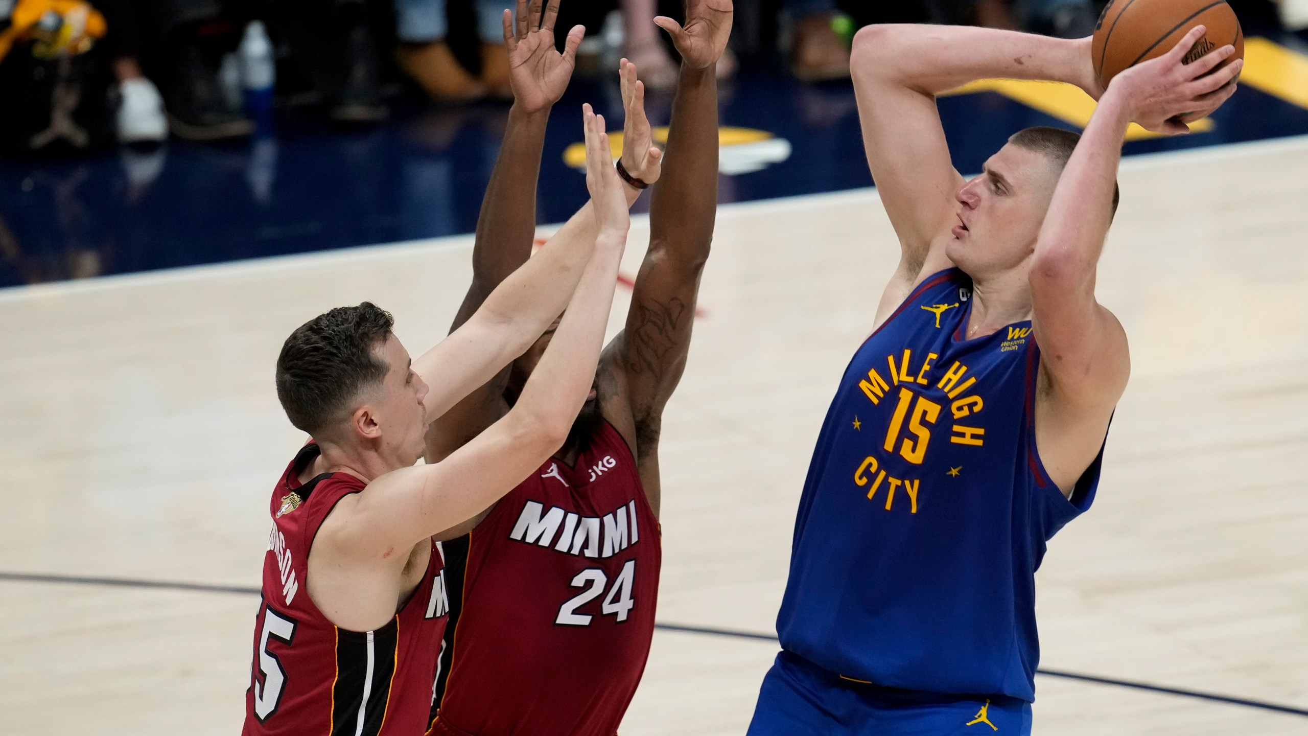 Denver Nuggets center Nikola Jokic, right, shoots over Miami Heat forwards Duncan Robinson, left, and Haywood Highsmith during the first half of Game 1 of basketball's NBA Finals, Thursday, June 1, 2023, in Denver. (AP Photo/David Zalubowski)