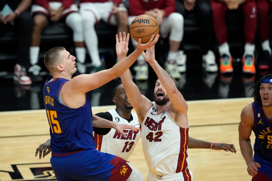 Denver Nuggets center Nikola Jokic (15) drives to the basket over Miami Heat forward Kevin Love (42) during the second half of Game 3 of the NBA Finals basketball game, Wednesday, June 7, 2023, in Miami. (AP Photo/Rebecca Blackwell)