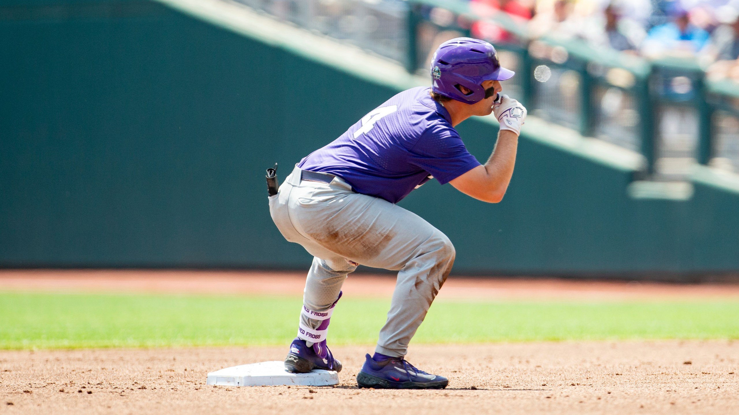 TCU base runner Kurtis Byrne (4) celebrates a double in the second inning against Oral Roberts in a baseball game at the NCAA College World Series in Omaha, Neb., Tuesday, June 20, 2023. (AP Photo/John Peterson)