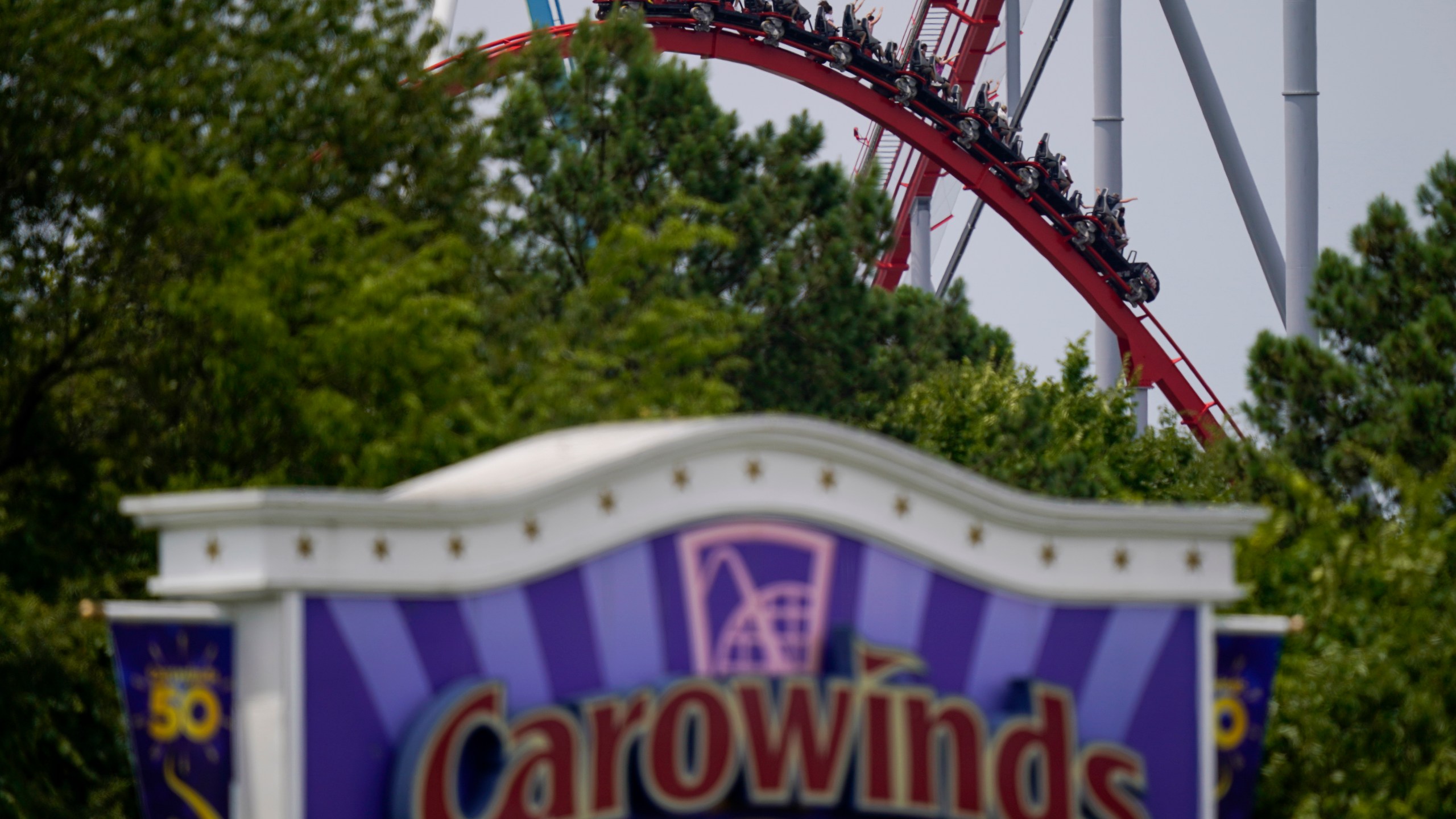 People ride a roller coaster at the Carowinds amusement park on Monday, July 3, 2023, in Charlotte, N.C. (AP Photo/Erik Verduzco)