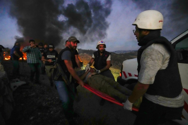 Civil Defence workers carry Qatar's Al-Jazeera TV cameraman Elie Brakhya who was injured by Israeli shelling, at Alma al-Shaab border village with Israel, south Lebanon, Friday, Oct. 13, 2023. Reporters Without Borders, or RSF, a watchdog group advocating for press freedom said Sunday, Oct. 29, that the strikes that hit a group of journalists in southern Lebanon earlier this month, killing one, were targeted rather than accidental and that the journalists were clearly identified as press. (AP Photo/Hassan Ammar)