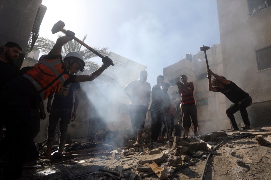 Palestinians look for survivors under the rubble of a destroyed building following an Israeli airstrike in Khan Younis refugee camp, southern Gaza Strip, Monday, Nov. 6, 2023. (AP Photo/Mohammed Dahman)