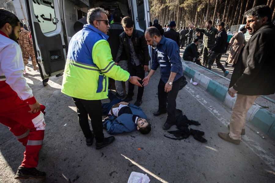 An injured man gets aid after an explosion in Kerman, Iran, Wednesday, Jan. 3, 2024. Iran says the deadly twin bomb blasts occurred at an event honoring a prominent Iranian general slain in a U.S. airstrike in 2020. (Mahdi Karbakhsh Ravari/Mehr News Agnecy via AP)