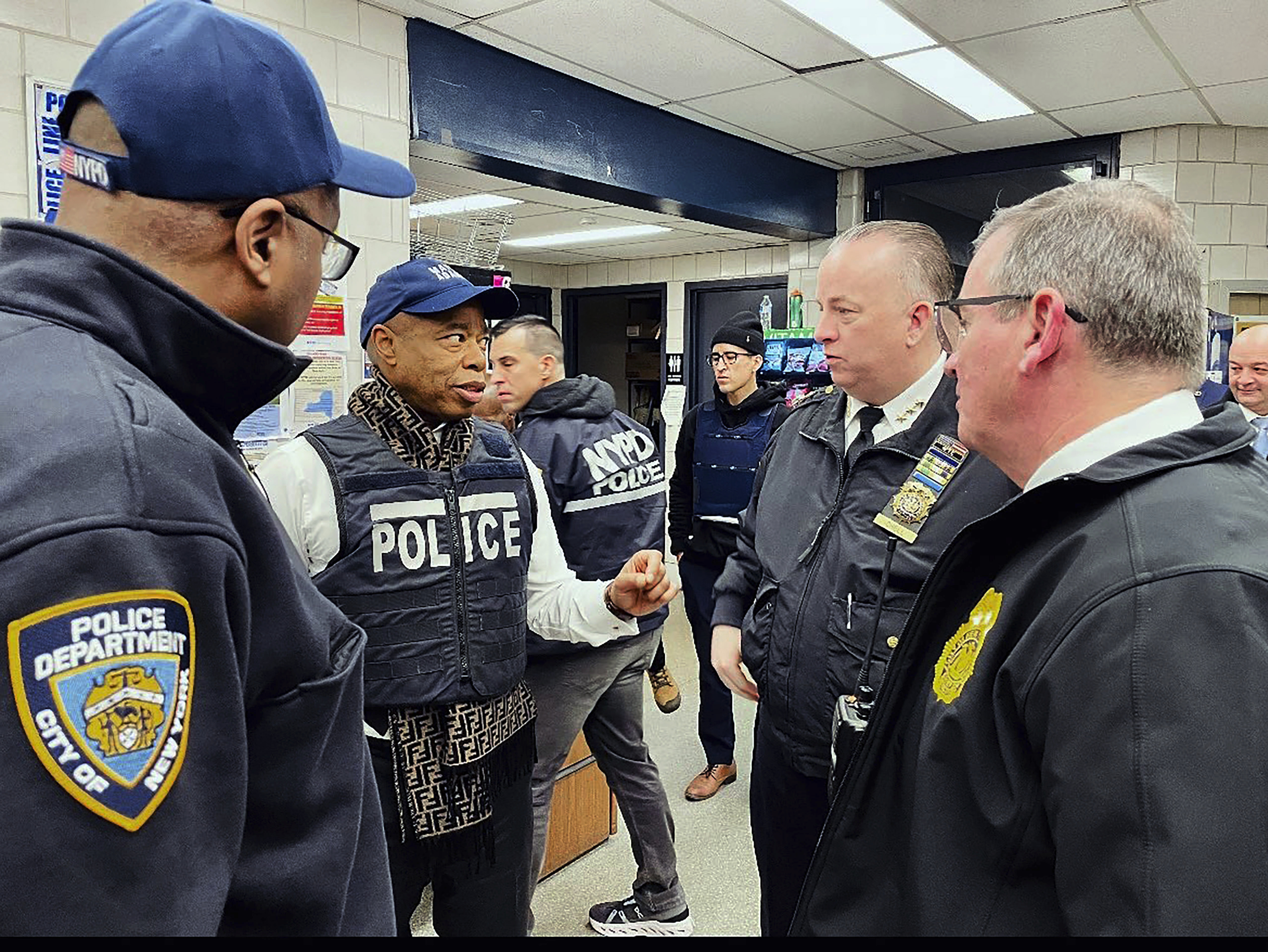 This photo provided by the Office of New York City Police Department Assistant Commissioner Kaz Daughtry, Monday, Feb. 5, 2024, shows New York Mayor Eric Adams, second left, who joined investigators and specialized teams as they carried out a search warrant. The raid, in the Bronx borough of New York, targeting suspects in a cell phone theft ring came as Adams and police officials have been promising a crackdown on crimes committed by migrants, following a brawl between migrants and police officers in Times Square. (Office of New York City Police Department Assistant Commissioner Kaz Daughtry via AP)