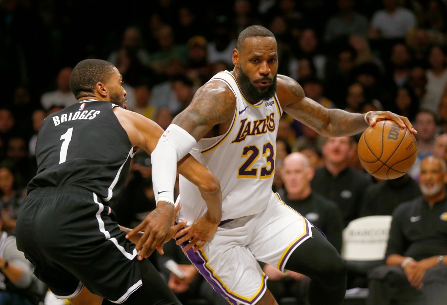 Los Angeles Lakers forward LeBron James (23) drives around Brooklyn Nets guard Mikal Bridges (1) during the first half of an NBA basketball game Sunday, March 31, 2024, in New York. (AP Photo/John Munson)