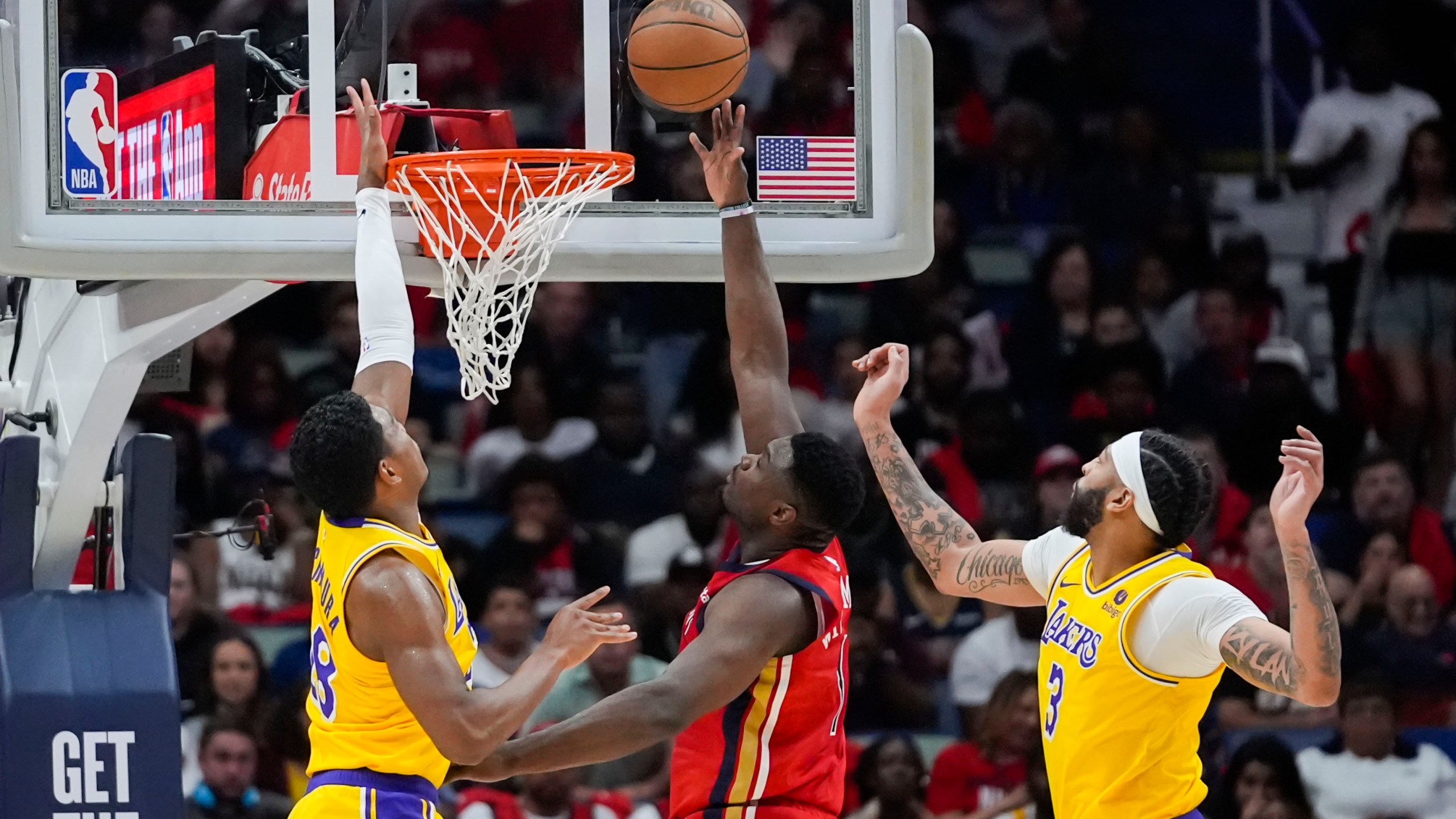 New Orleans Pelicans forward Zion Williamson (1) goes to the basket between Los Angeles Lakers forward Rui Hachimura and forward Anthony Davis (3) in the first half of an NBA basketball play-in tournament game Tuesday, April 16, 2024, in New Orleans. (AP Photo/Gerald Herbert)