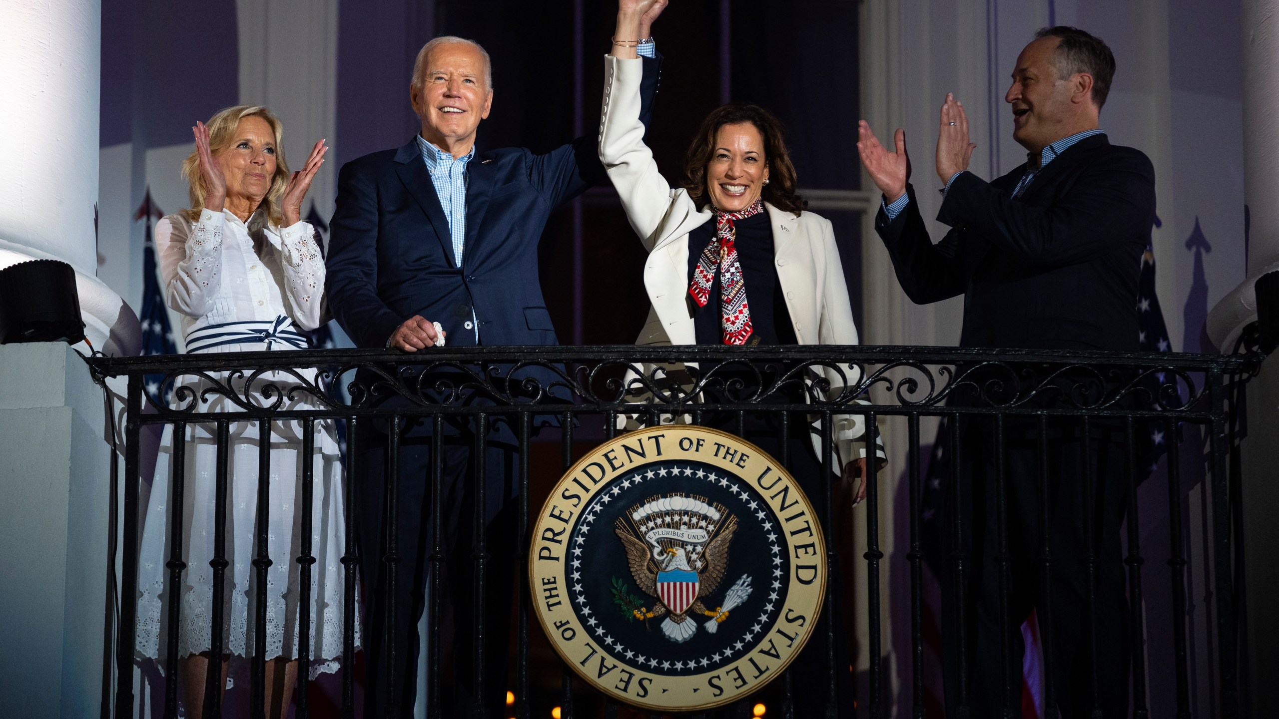 First lady Jill Biden and second gentleman Douglass Emhoff watch as President Joe Biden raises the hand of Vice President Kamala Harris as they view the Independence Day firework display over the National Mall from the balcony of the White House, Thursday, July 4, 2024, in Washington. (AP Photo/Evan Vucci)