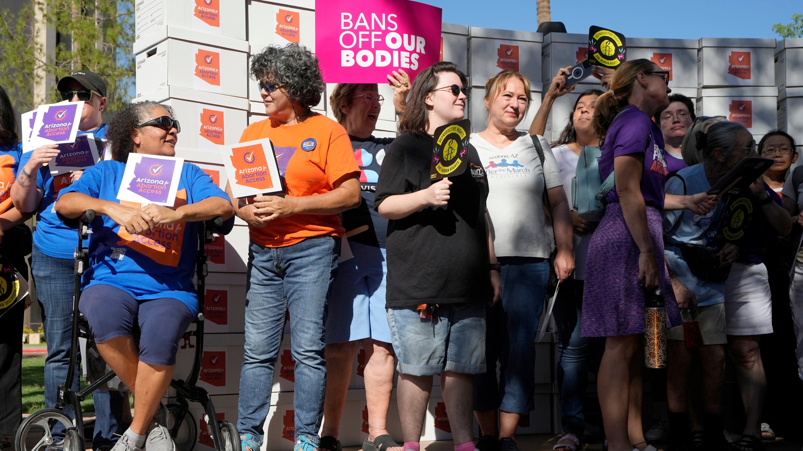 FILE - Arizona abortion-rights supporters gather for a news conference prior to delivering over 800,000 petition signatures to the capitol to get abortion rights on the November general election ballot Wednesday, July 3, 2024, in Phoenix. Abortion access ballot measures are the center of a new wave of legal and procedural questions across the U.S., including Arizona, where there's a dispute over language to describe a measure. (AP Photo/Ross D. Franklin, File)