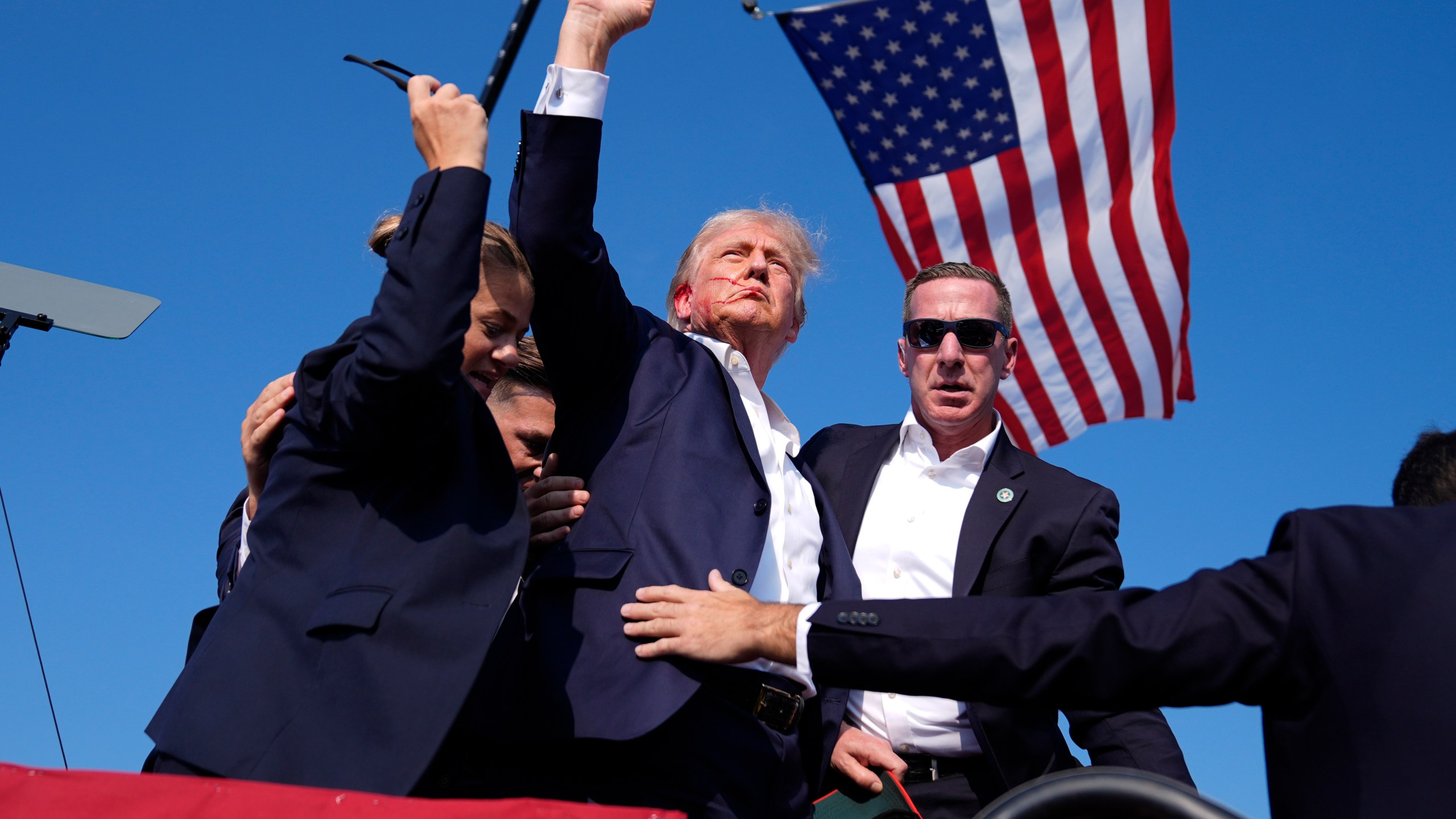 Republican presidential candidate former President Donald Trump gestures as he is surrounded by U.S. Secret Service agents as he leaves the stage at a campaign rally, Saturday, July 13, 2024, in Butler, Pa. (AP Photo/Evan Vucci)