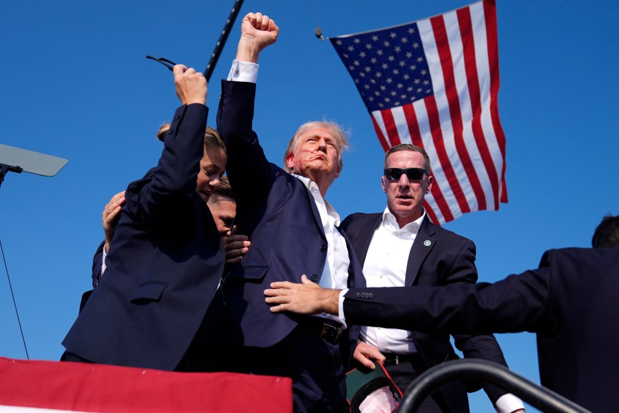 Republican presidential candidate former President Donald Trump gestures as he is surrounded by U.S. Secret Service agents as he leaves the stage at a campaign rally, Saturday, July 13, 2024, in Butler, Pa. (AP Photo/Evan Vucci)