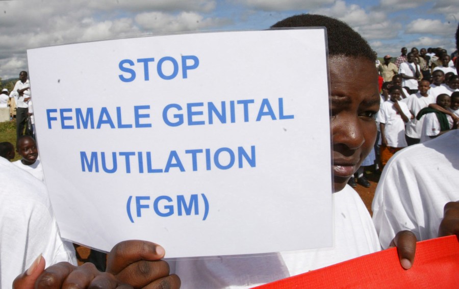 FILE - A Masai girl holds a protest sign during the anti-Female Genital Mutilation (FGM) run in Kilgoris, Kenya, on April 21, 2007. Lawmakers in the West African nation of Gambia on Monday July 15, 2024 rejected a bill that would have overturned a ban on female genital cutting. The attempt to become the first country in the world to reverse such a ban had been closely followed by activists abroad. (AP Photo/Sayyid Azim, File)