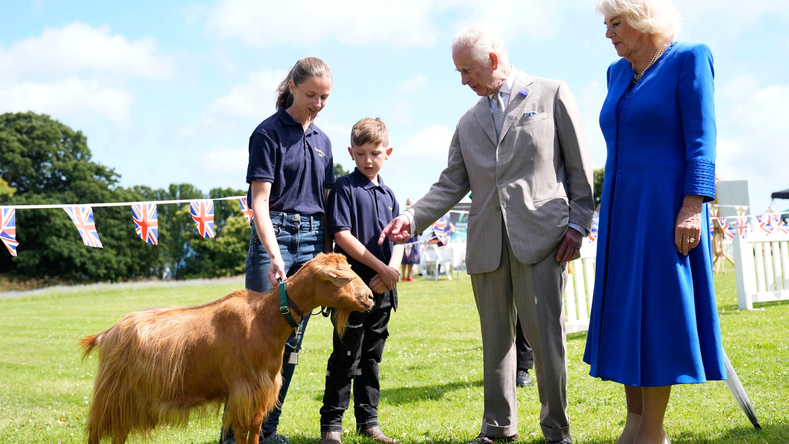 Britain's King Charles III, centre right, and Queen Camilla, right, view a rare Golden Guernsey Goats during a visit to Les Cotils at L'Hyvreuse, in Saint Peter Port, Guernsey during their two day visit to the Channel Islands, Tuesday July 16, 2024. (Andrew Matthews/PA via AP)