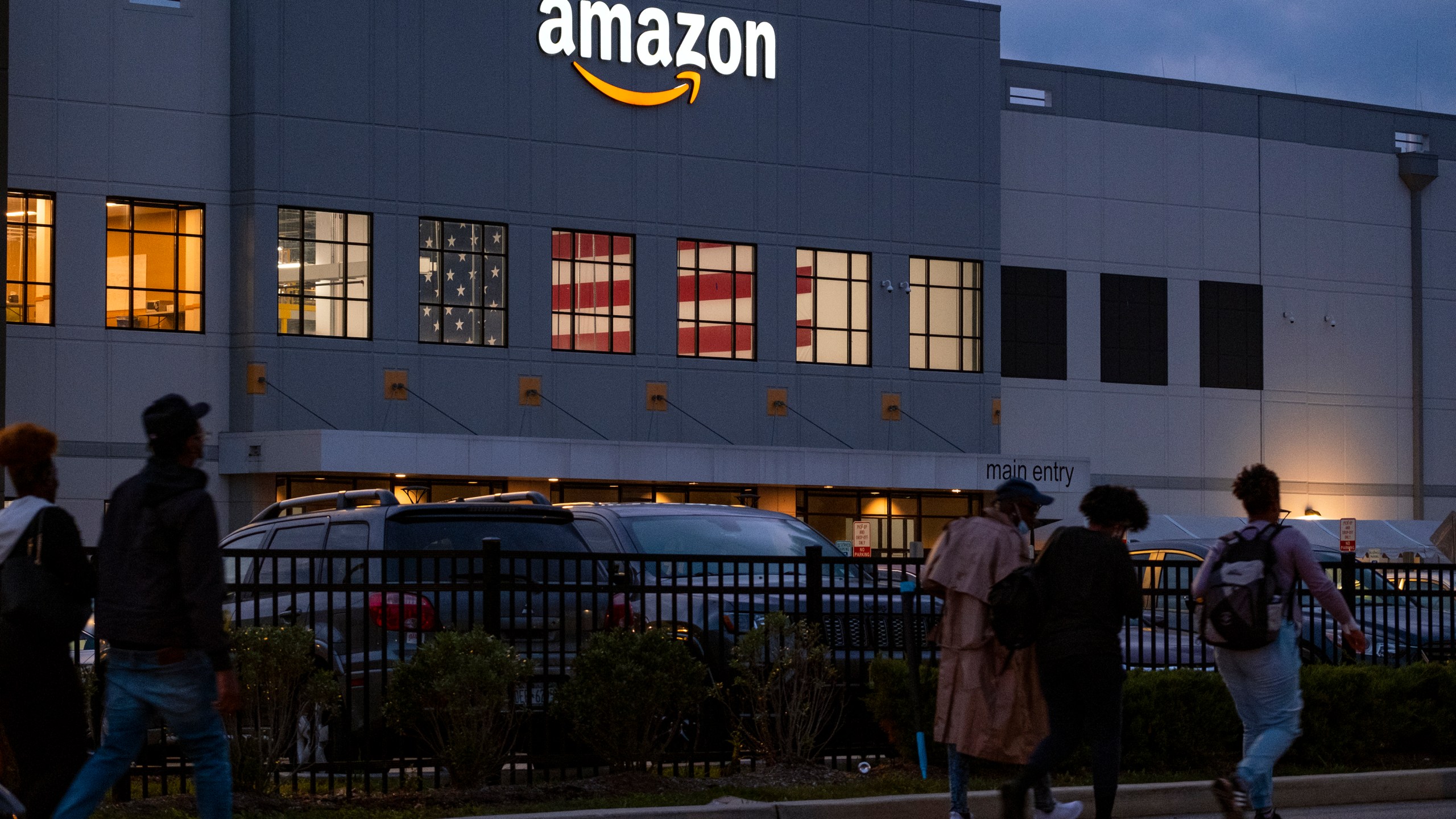 FILE - People arrive for work at the Amazon distribution center in the Staten Island borough of New York, on Oct. 25, 2021. A report released by U.S. Senator Bernie Sanders said Amazon's popular Prime Day sales event has been "a major cause of injuries" for warehouse workers who organize packages at its facilities across the country. (AP Photo/Craig Ruttle, File)