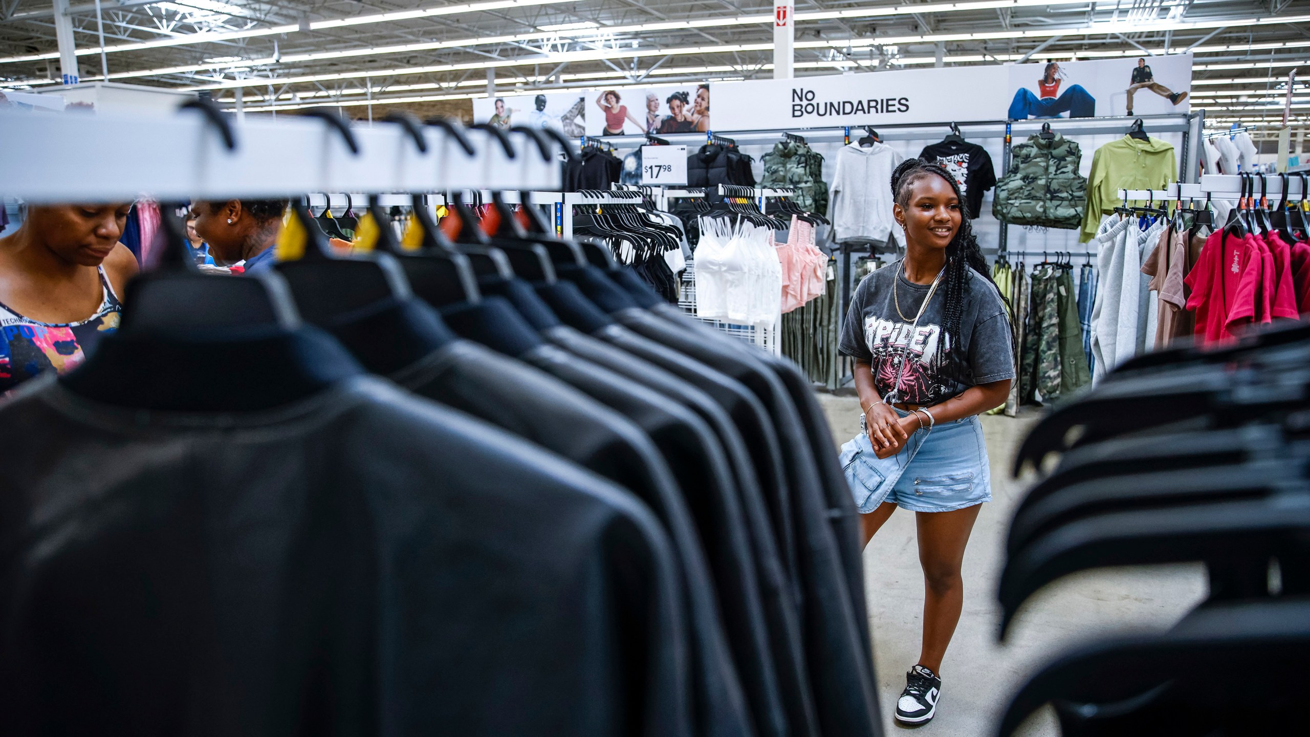 Za'kyra Davis checks out clothes from Walmart's No Boundaries collection at a Walmart Superstore in Secaucus, New Jersey, Thursday, July 11, 2024. Davis, who shops at chains like Rue21 and Forever 21 and gets inspired by fashion trends she sees on social media, said she has been more open to buying clothes at Walmart in the past few months. (AP Photo/Eduardo Munoz Alvarez)