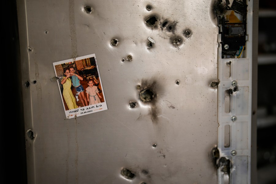 FILE - A photo hangs on a refrigerator next to bullet holes in a house at Kibbutz Kissufim in southern Israel, Saturday, Oct. 21, 2023. The Kibbutz was overrun by Hamas militants from the nearby Gaza Strip on Oct. 7, when they killed and captured many Israelis. Human Rights Watch released a report Wednesday, July 17, 2024, saying Hamas-led armed groups committed numerous war crimes during the Oct. 7 attack on southern Israel that precipitated the ongoing war in the Gaza Strip. (AP Photo/Francisco Seco, File)