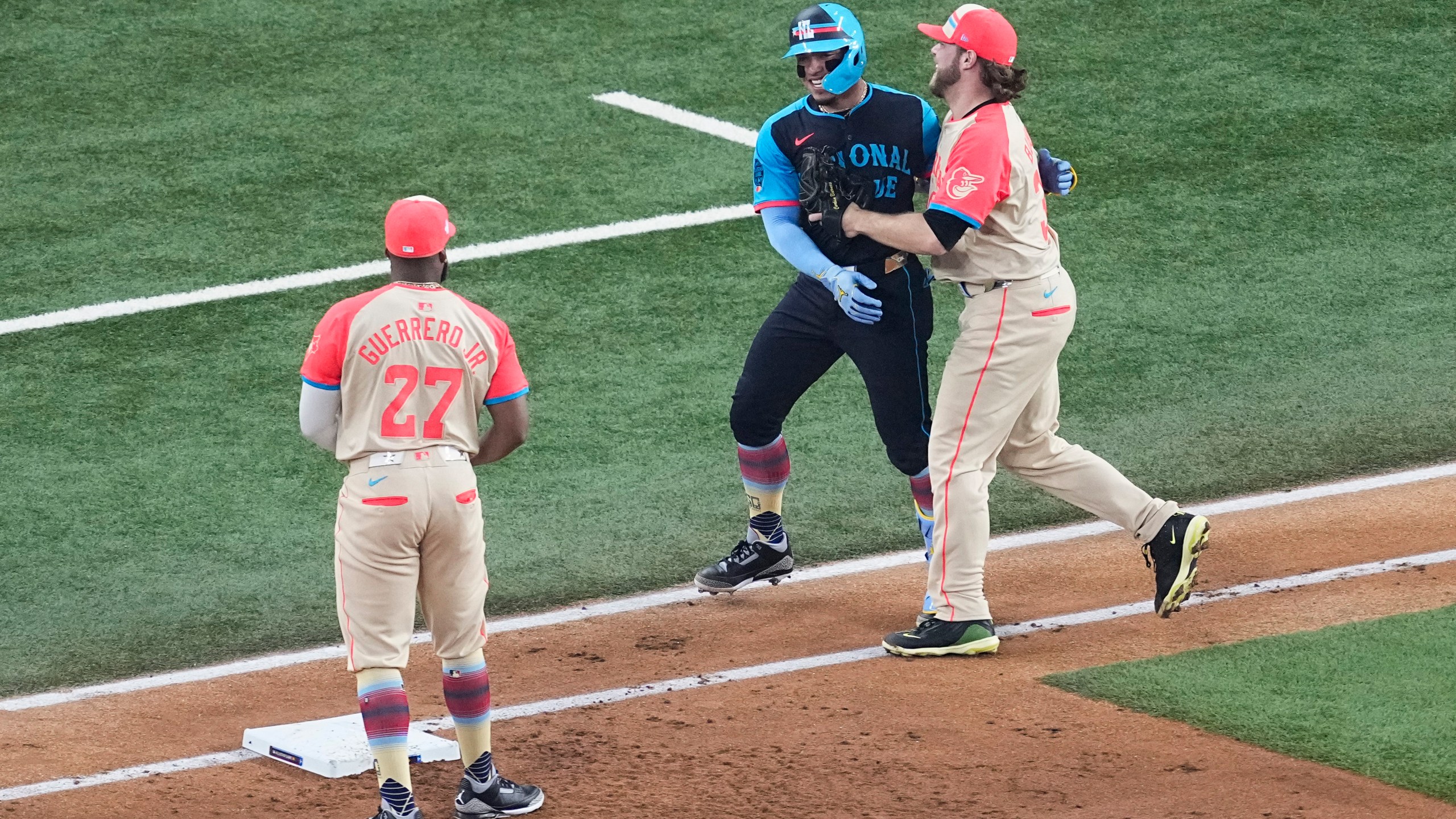 National League's William Contreras, center, of the Milwaukee Brewers, jokes around with American League's Corbin Burnes, right, during the first inning of the MLB All-Star baseball game, Tuesday, July 16, 2024, in Arlington, Texas. (AP Photo/Tony Gutierrez)