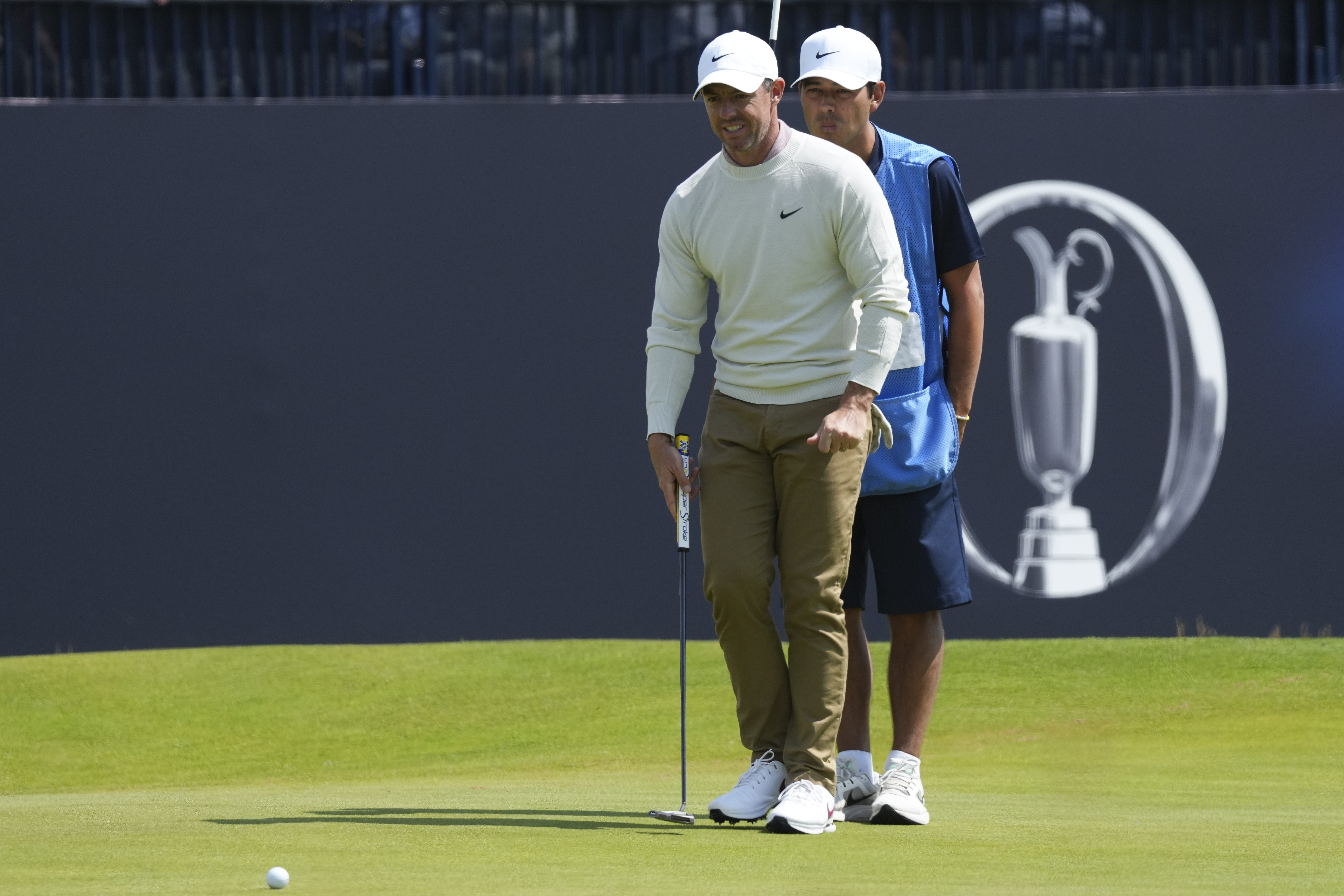 Rory McIlroy of Northern Ireland line sup a putt on the 18th green with his caddy Harry Diamond during a practice round ahead of the British Open Golf Championships at Royal Troon golf club in Troon, Scotland, Wednesday, July 17, 2024. (AP Photo/Jon Super)