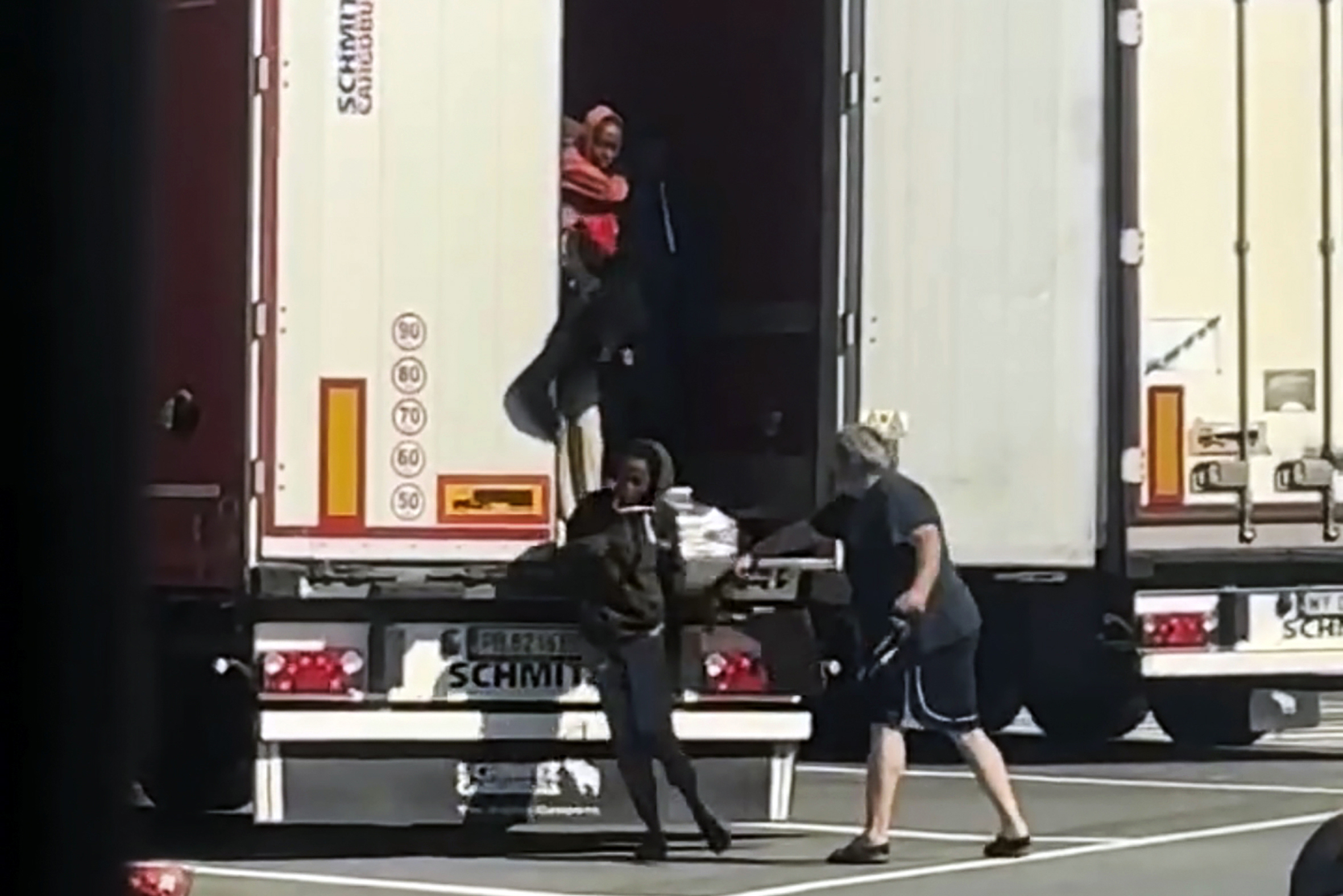 In this frame grab taken from a truck driver strikes female migrants with the hardware end of a cargo strap as they exited from the back of his truck at rest stop near the French border in Ventimiglia, Monday, July 15, 2024. According to authorities, smugglers loaded the 12 Eritrean women on to the back of the truck at a rest stop near the French border on Monday while the trucker was having lunch. Once closed inside the truck, the women apparently started agitating due to the heat, with outdoor temperatures over 30 degrees, drawing the driver's attention, city officials said. While the truck driver was being sought, officials said he was unlikely to face any sanction as it would require the women to make a formal complaint. (UGC via AP)