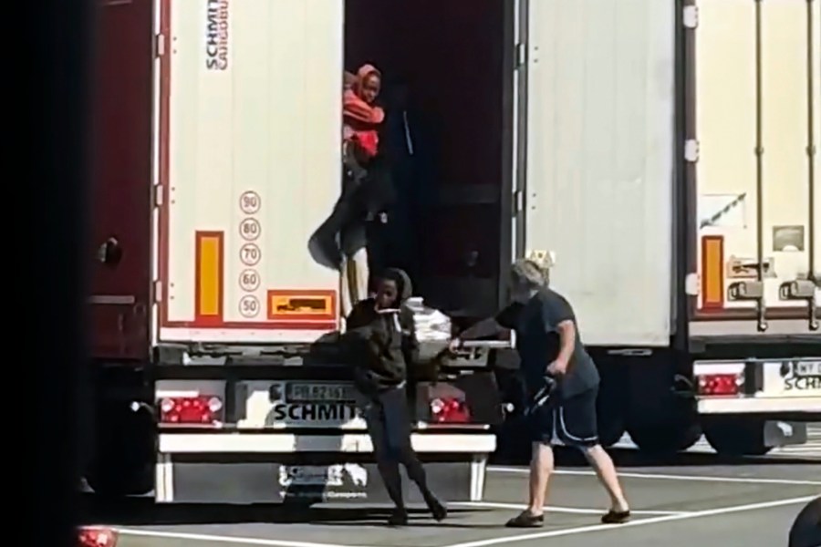 In this frame grab taken from a truck driver strikes female migrants with the hardware end of a cargo strap as they exited from the back of his truck at rest stop near the French border in Ventimiglia, Monday, July 15, 2024. According to authorities, smugglers loaded the 12 Eritrean women on to the back of the truck at a rest stop near the French border on Monday while the trucker was having lunch. Once closed inside the truck, the women apparently started agitating due to the heat, with outdoor temperatures over 30 degrees, drawing the driver's attention, city officials said. While the truck driver was being sought, officials said he was unlikely to face any sanction as it would require the women to make a formal complaint. (UGC via AP)