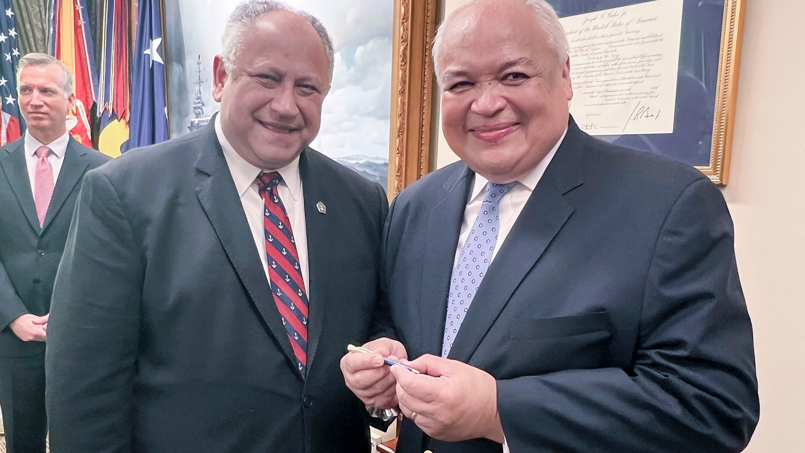 Thurgood Marshall, Jr., right, smiles as he receives the first pen from Navy Secretary Carlos Del Toro, Wednesday, July 17, 2024 at the Pentagon in Washington, after it was used to sign documents exonerating 256 Black sailors who were unjustly court martialed in 1944 after the horrific Port Chicago explosion in California. (AP Photo/Tara Copp)