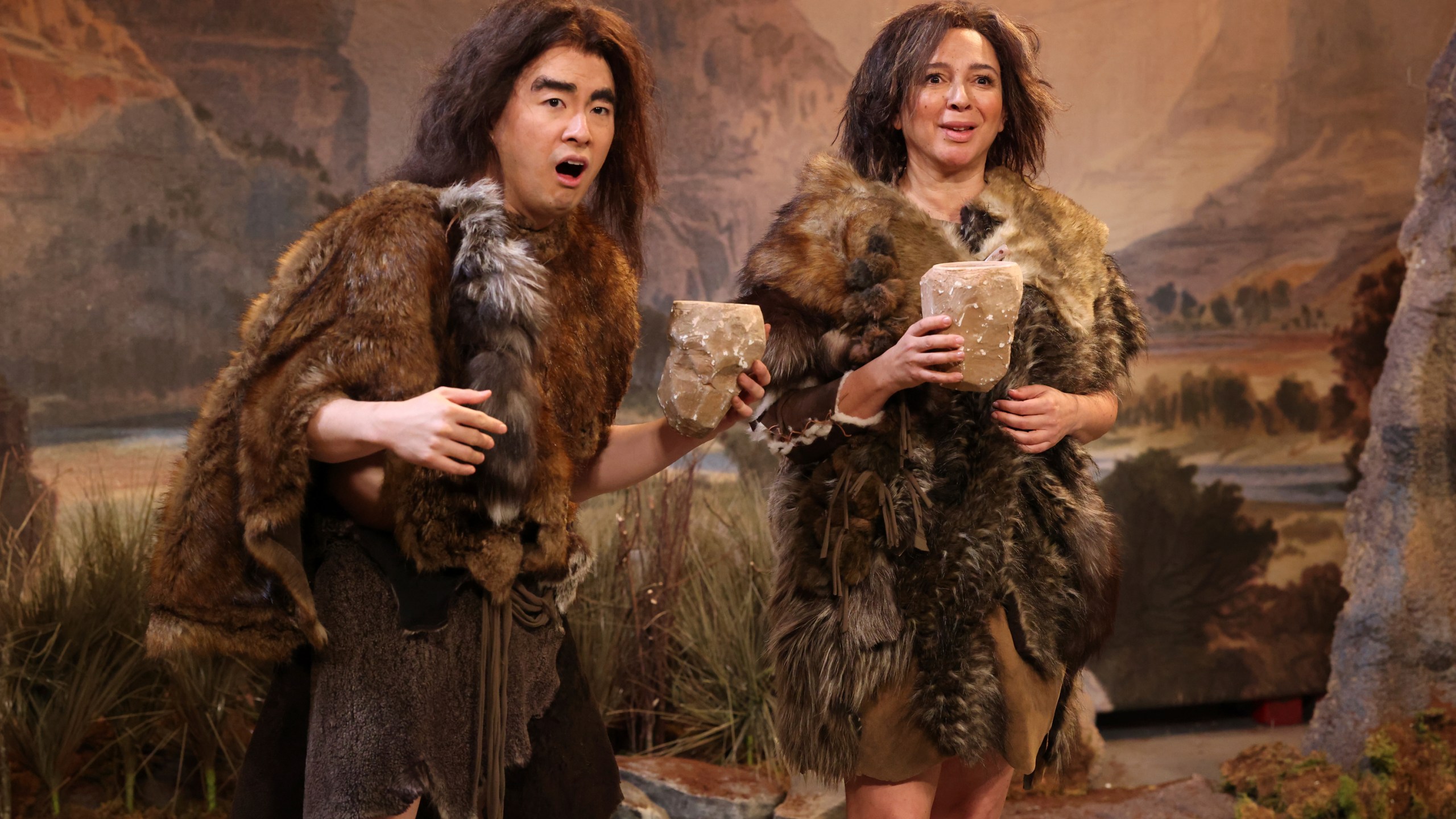 This image released by NBC shows Bowen Yang, left, and host Maya Rudolph during the "British Cavemen" sketch on "Saturday Night Live," in New York on May 11, 2024. (Will Heath/NBC via AP)